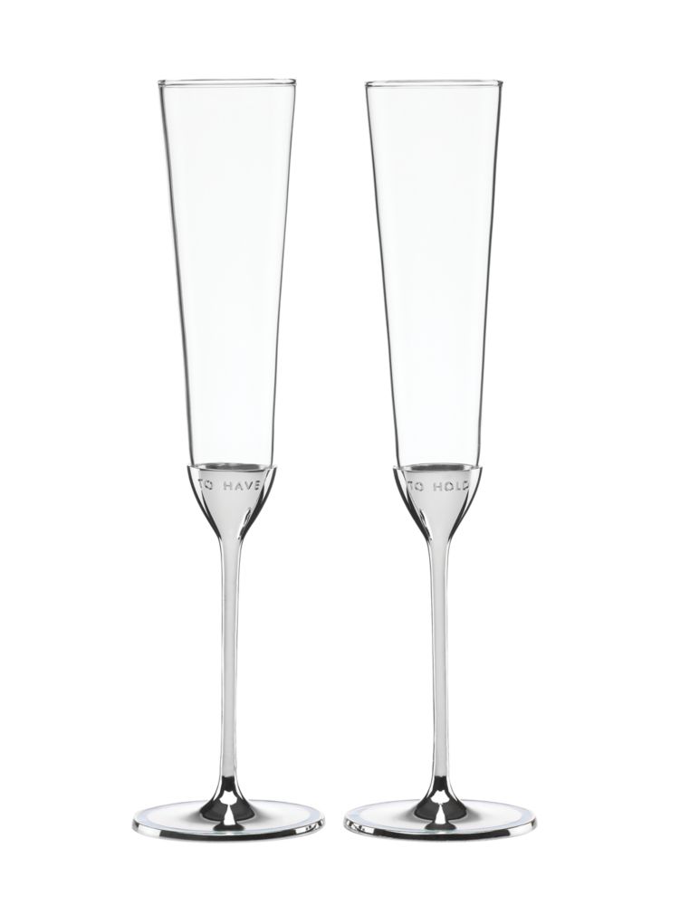 Champagne toast. Two filled champagne flutes touch in a spill over